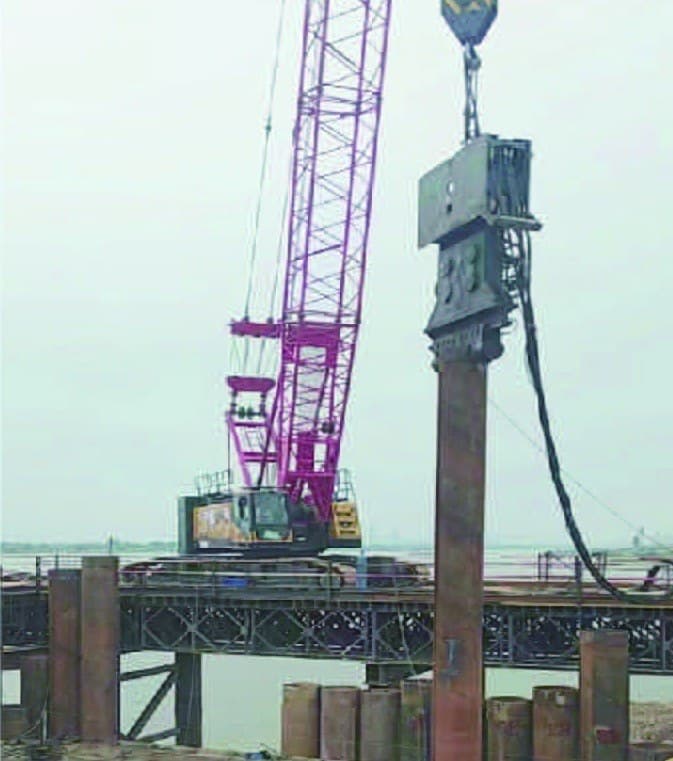 Installation of PC steel pipe piles for a water-side cofferdam.
